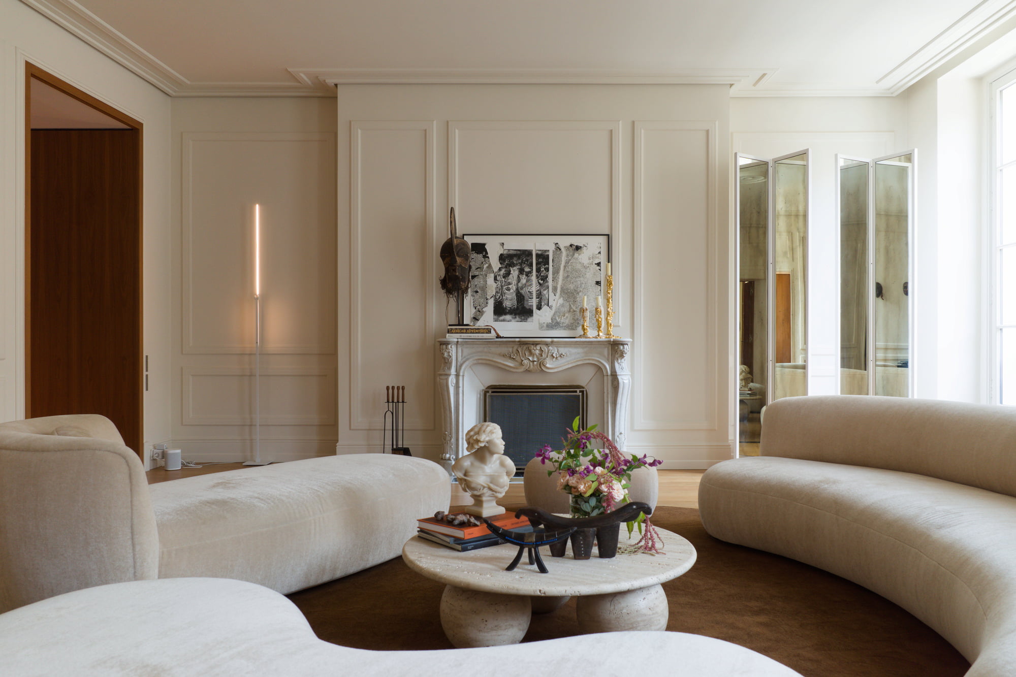 Bright Paris apartment furnished with contemporary design pieces and African art.