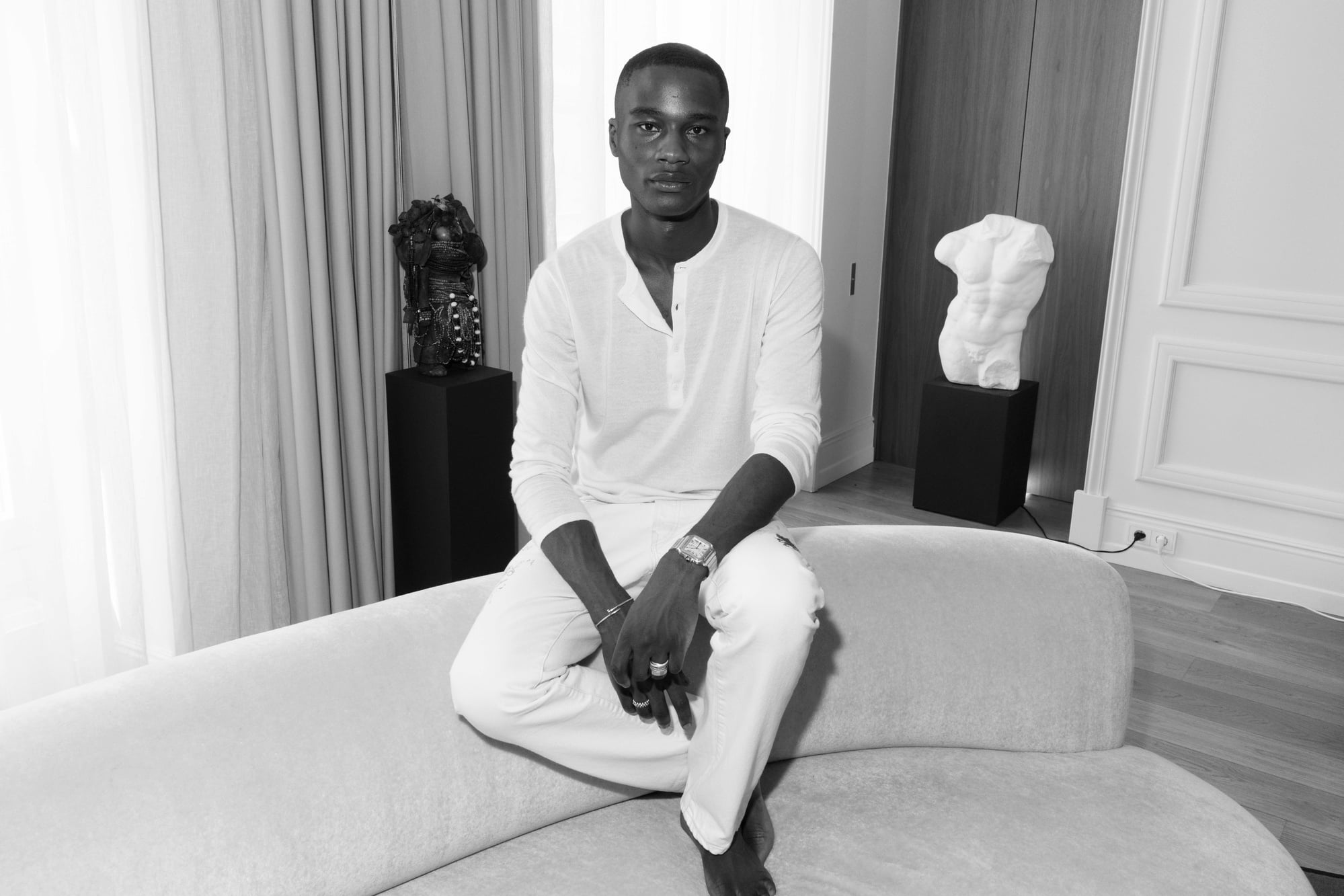 Black-and-white portrait of Randy Gowon seated in a contemporary Paris apartment.