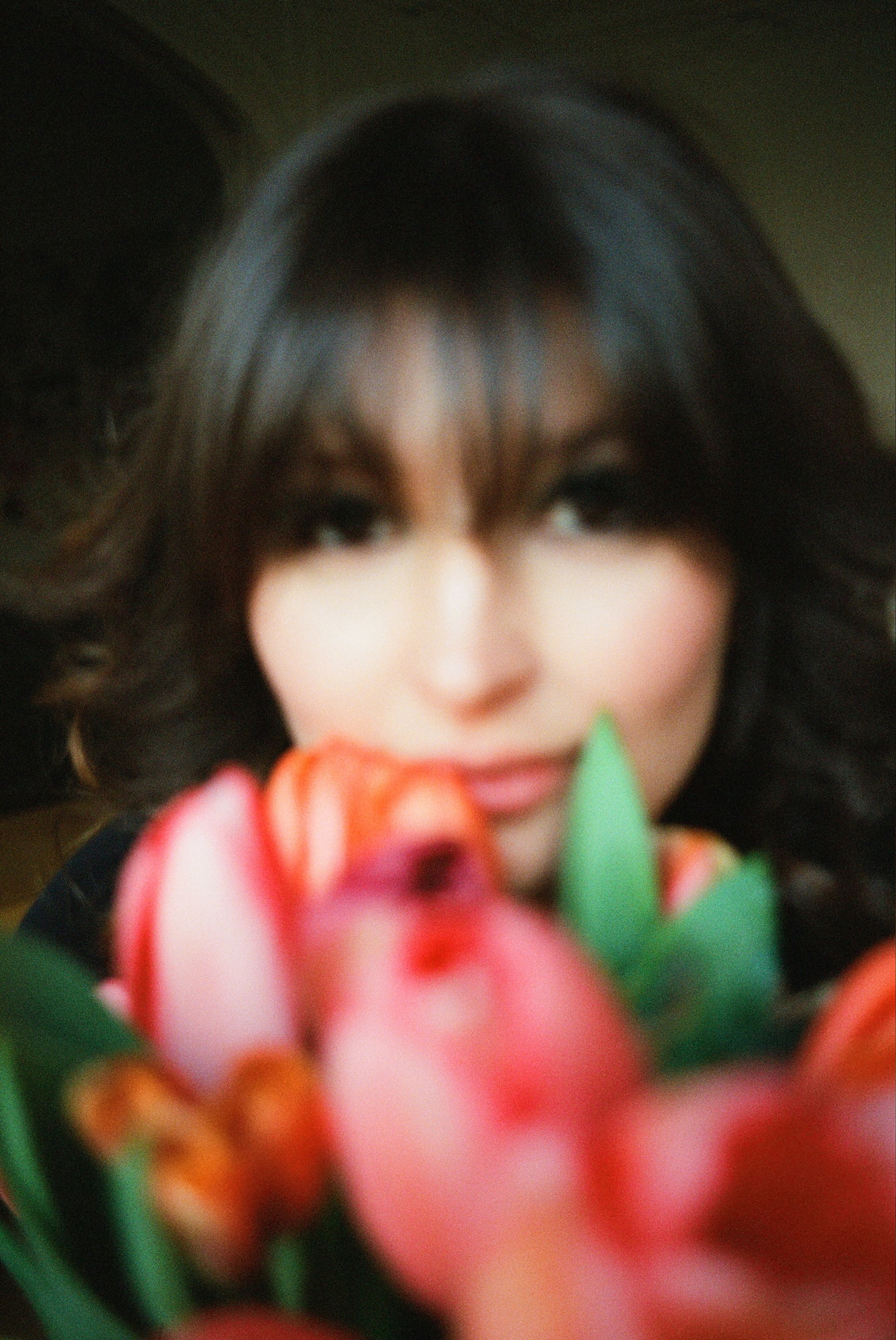 Blurred close portrait of Ariadna behind tulips at an apartment in Invalides, Paris