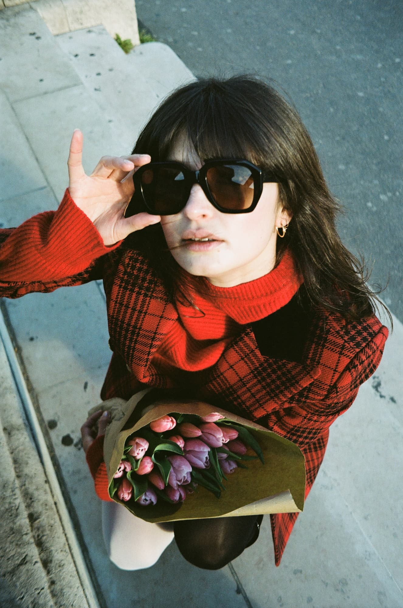 Ariadna looking up while holding tulips near the Pont Alexandre III in Paris