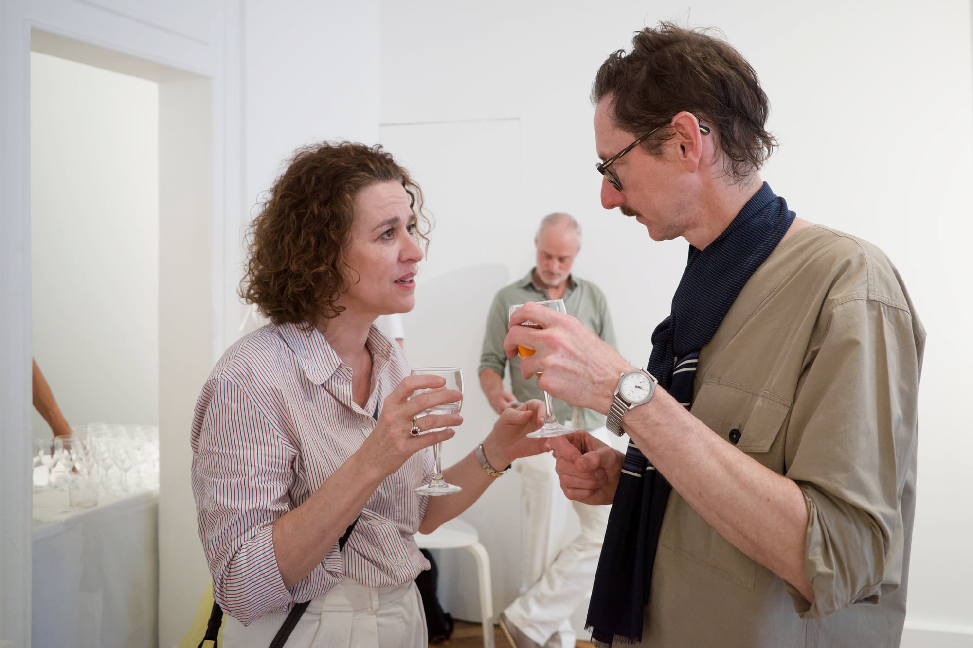 Woman and man talking with Anthony White while holding drinks during the Arty House gathering