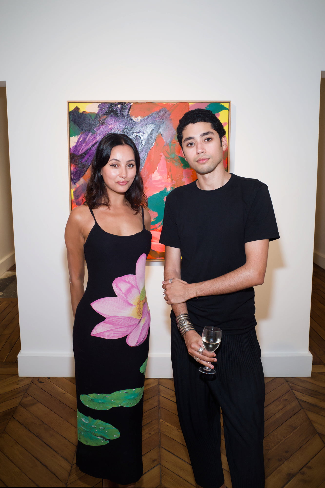 Arty House hosts, Samia Bahemmouche and Saad Ahellal, posing together in front of a colorful abstract painting