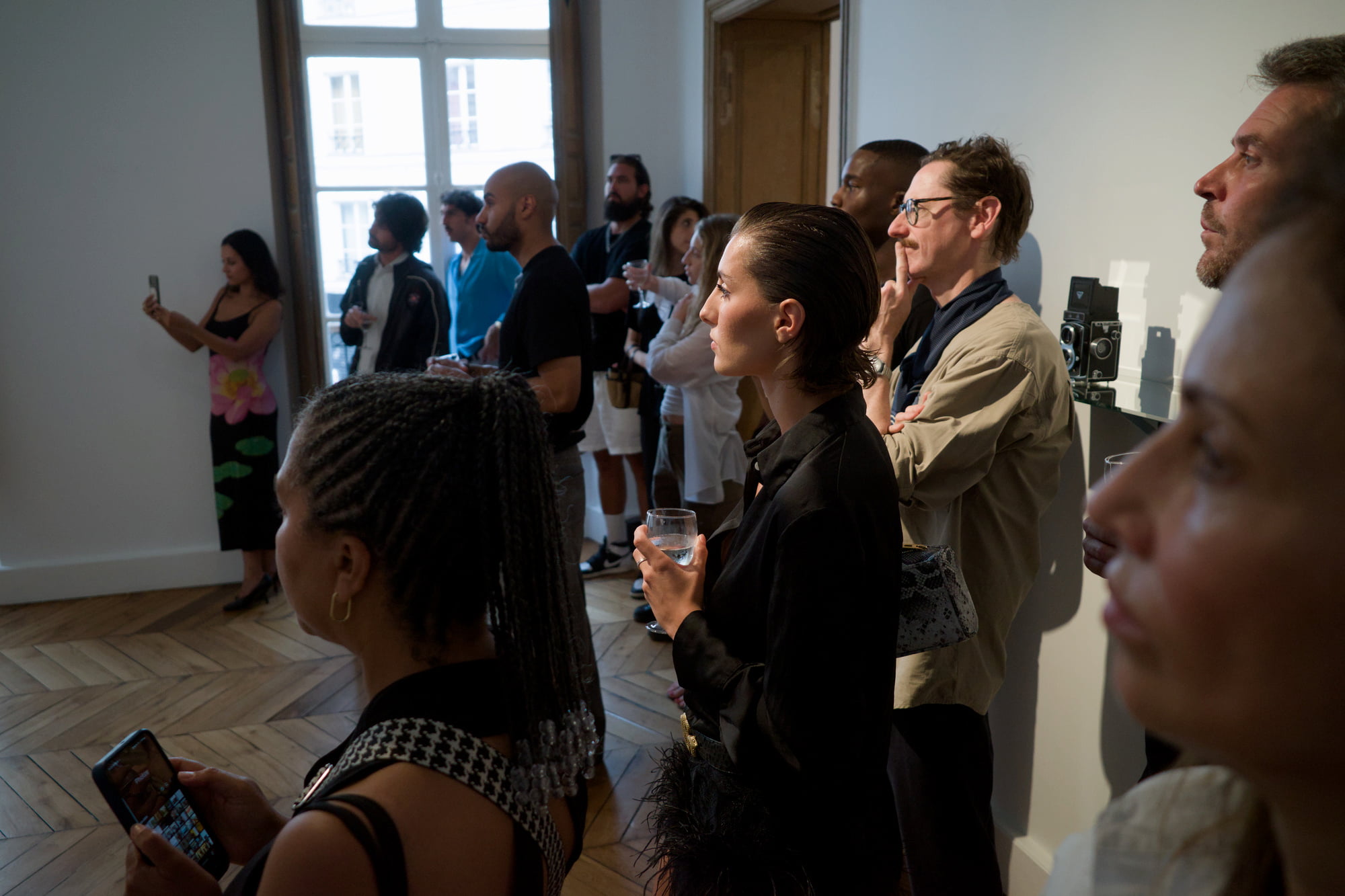 Clémence Navarro-Bastin, Anthony White and other guests listening to a presentation inside the gallery during Arty House