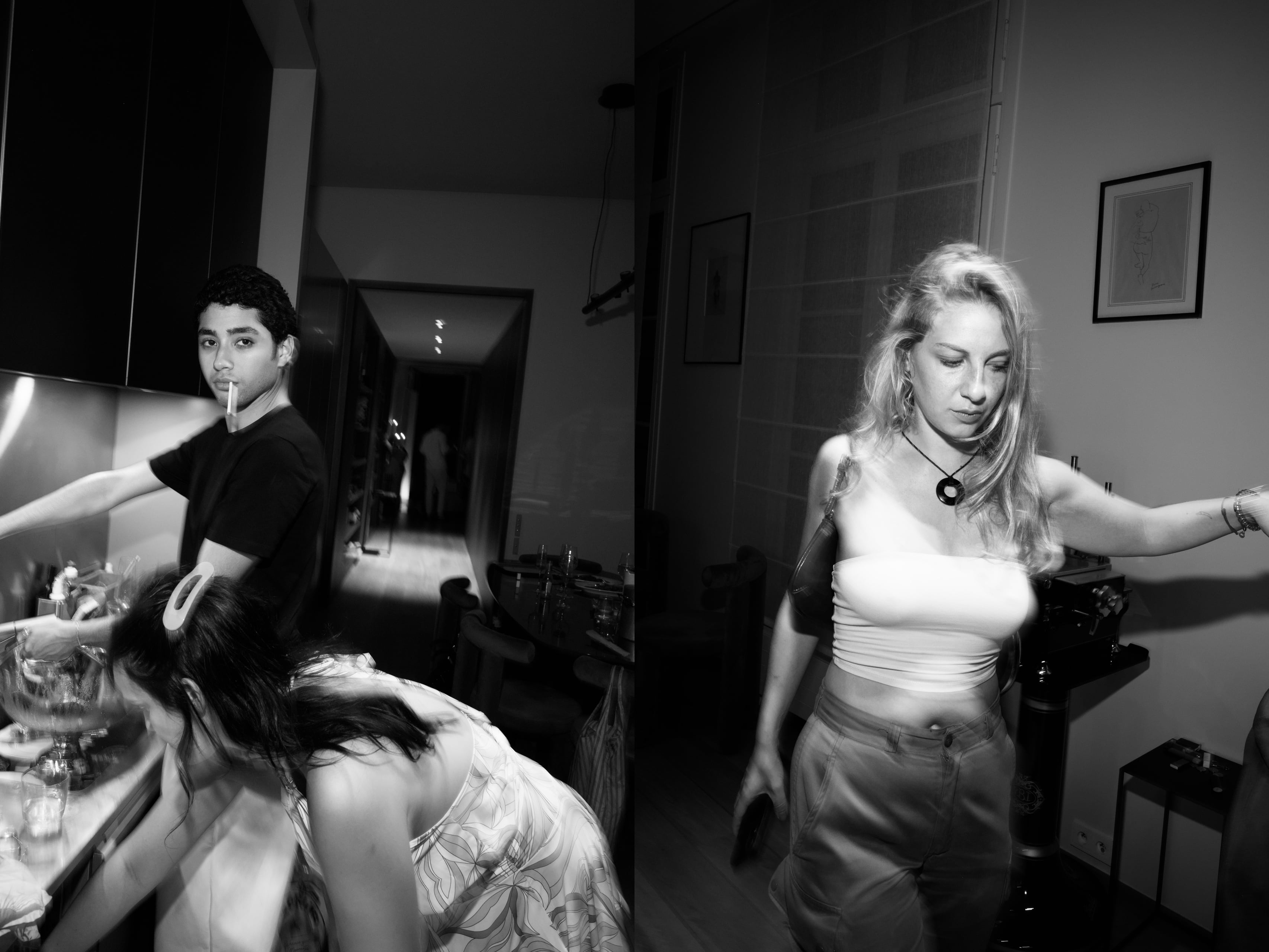Guests gathered in the kitchen while one looks toward the camera with a cigarette.