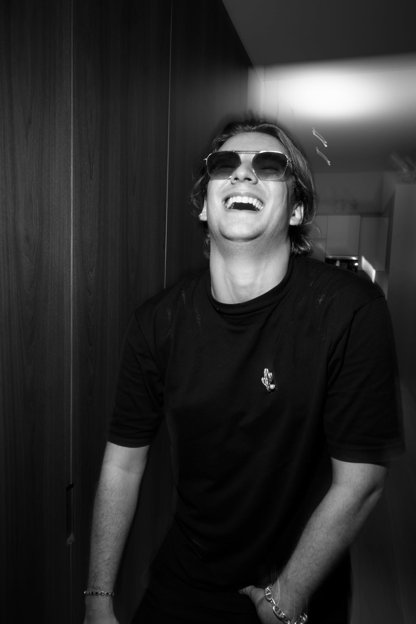 Laughing guest wearing sunglasses illuminated by direct flash.