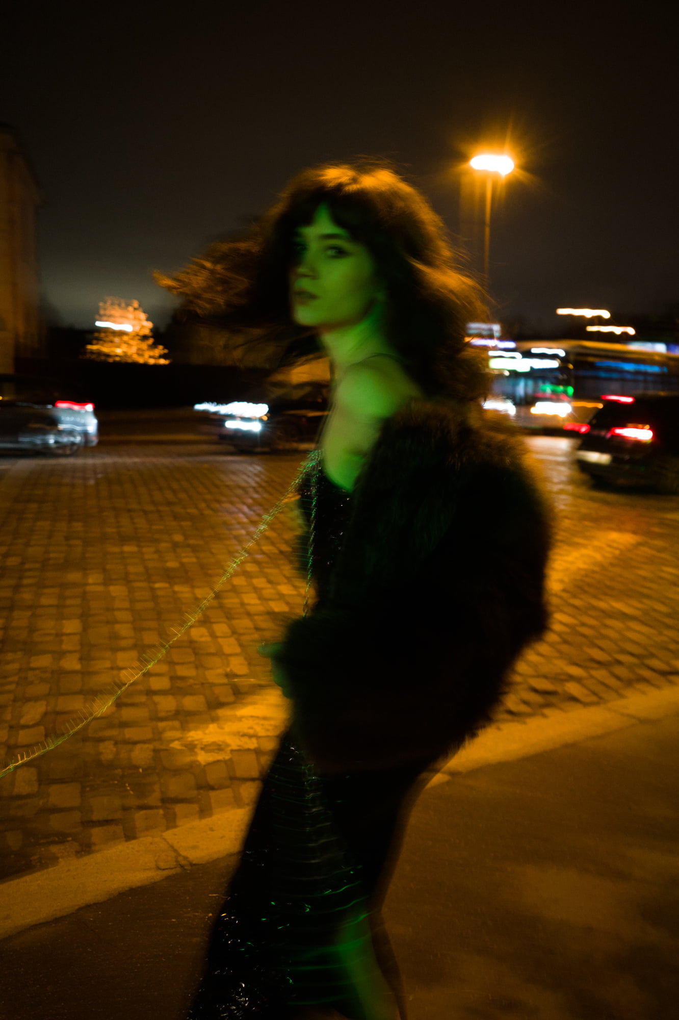 Polly Levin in motion at night in Paris wearing a fur stole and sequined BlancBloom AW25 dress