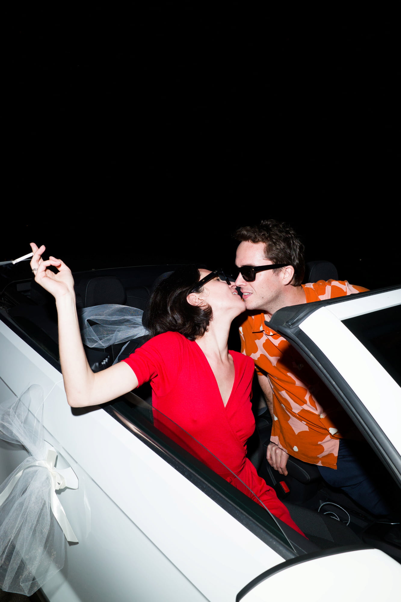 Gabriel and Eléa kissing in a white convertible after the wedding celebration.