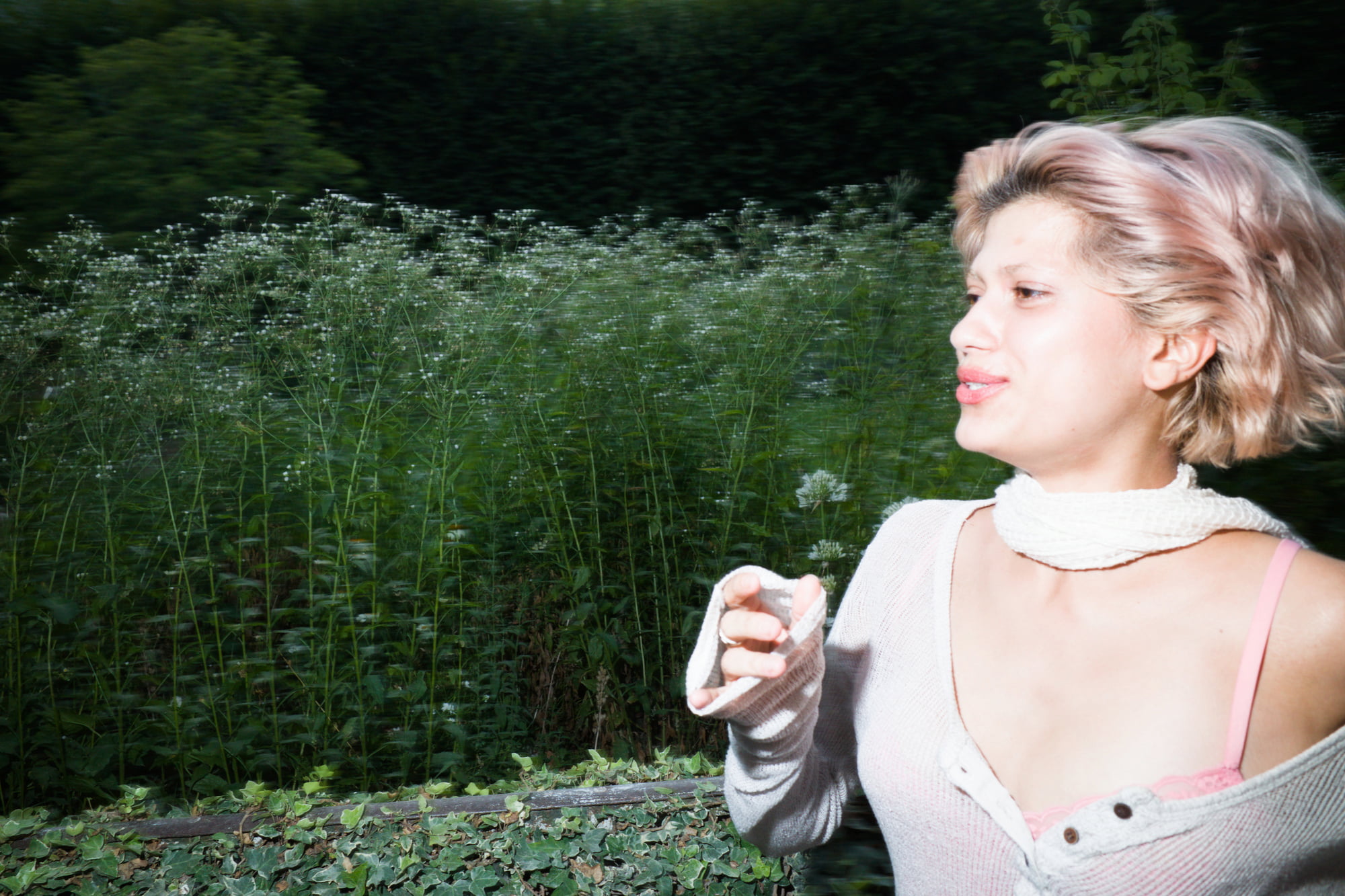 Side portrait of Juliette walking beside wildflowers in the Tuileries Garden.