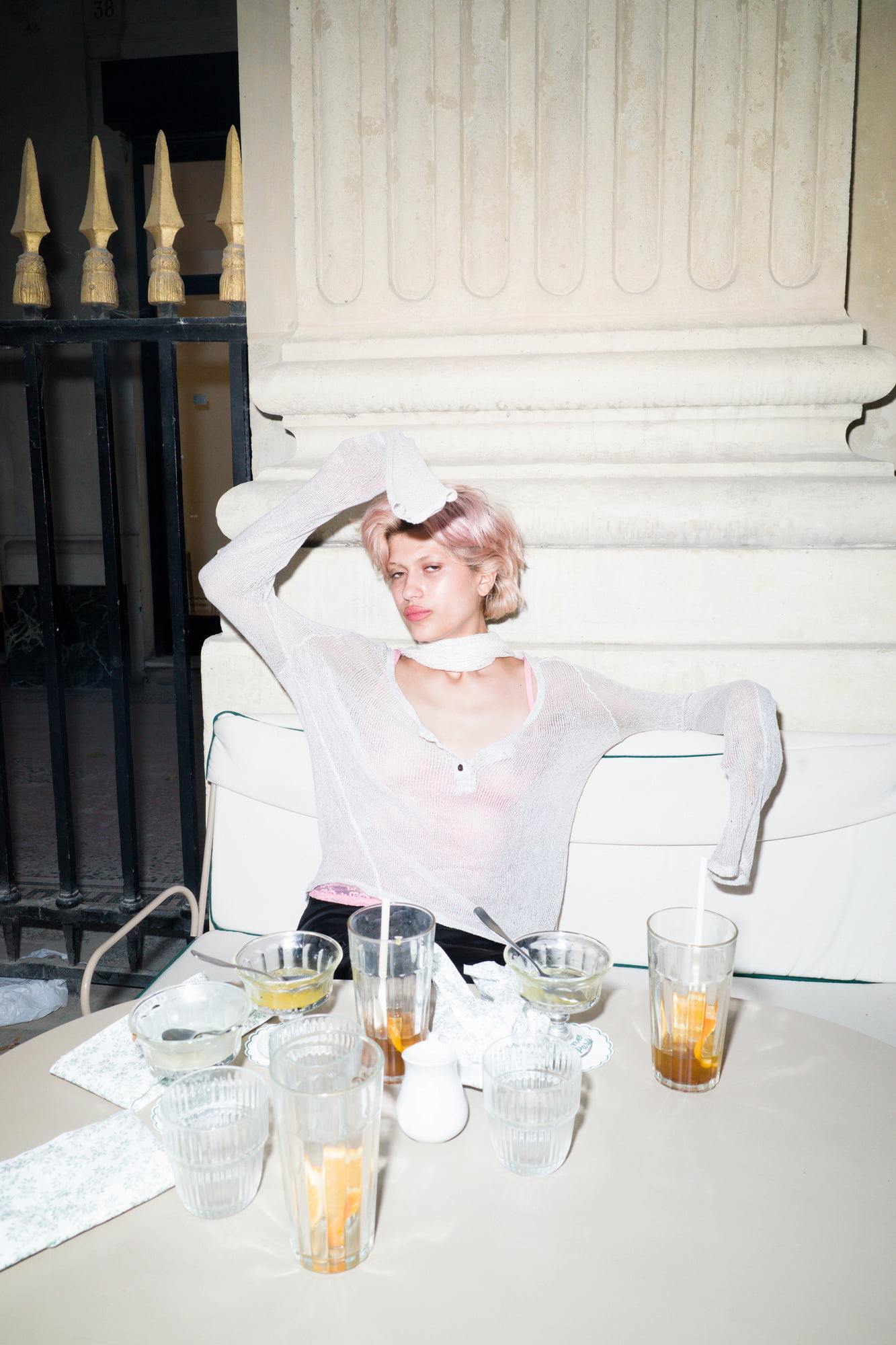 Portrait of Juliette reclining on a café bench after dinner, surrounded by empty glasses and plates.