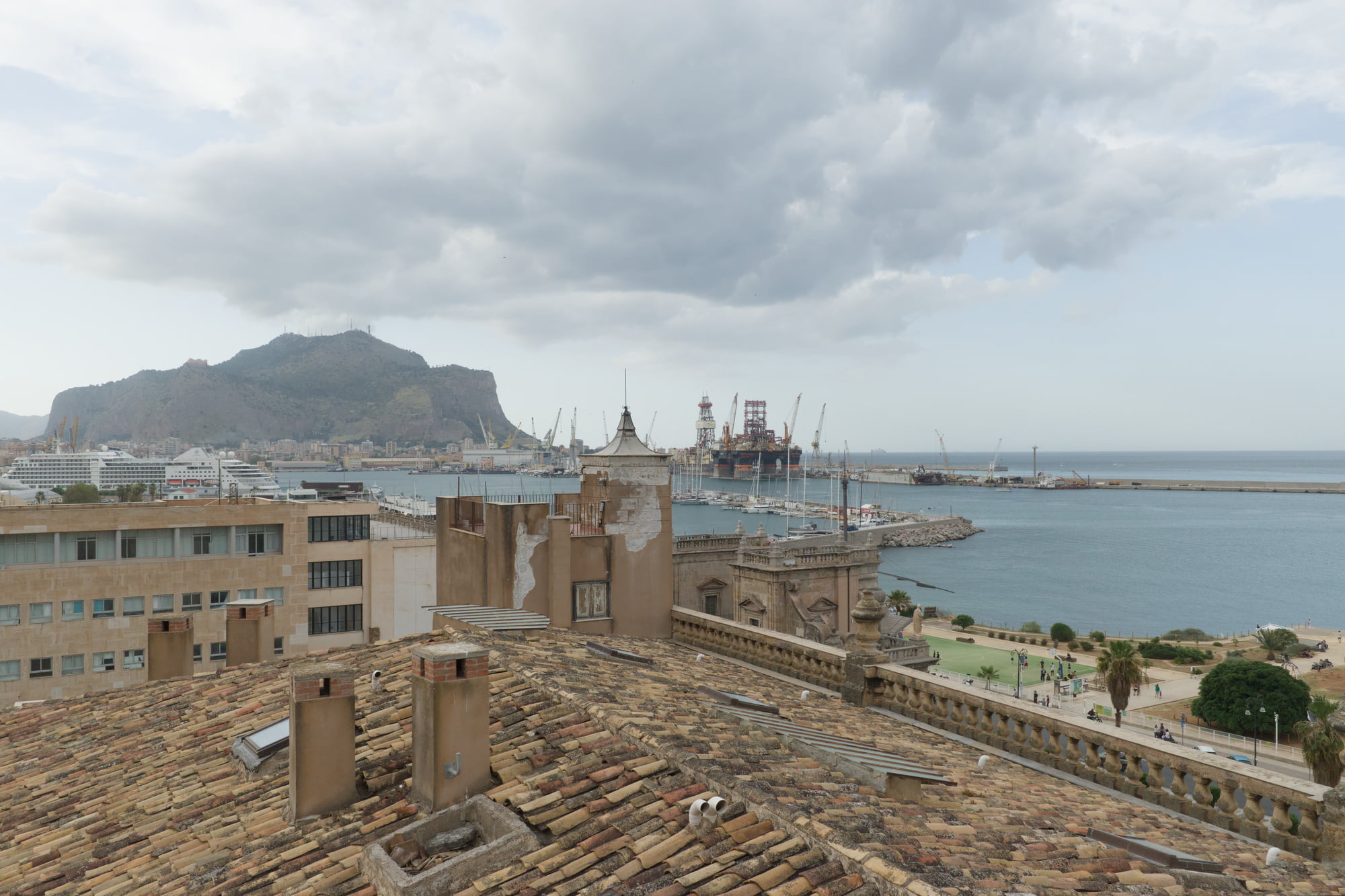 View from Palazzo Butera over Palermo rooftops, the harbor, mountains, and cloudy sky