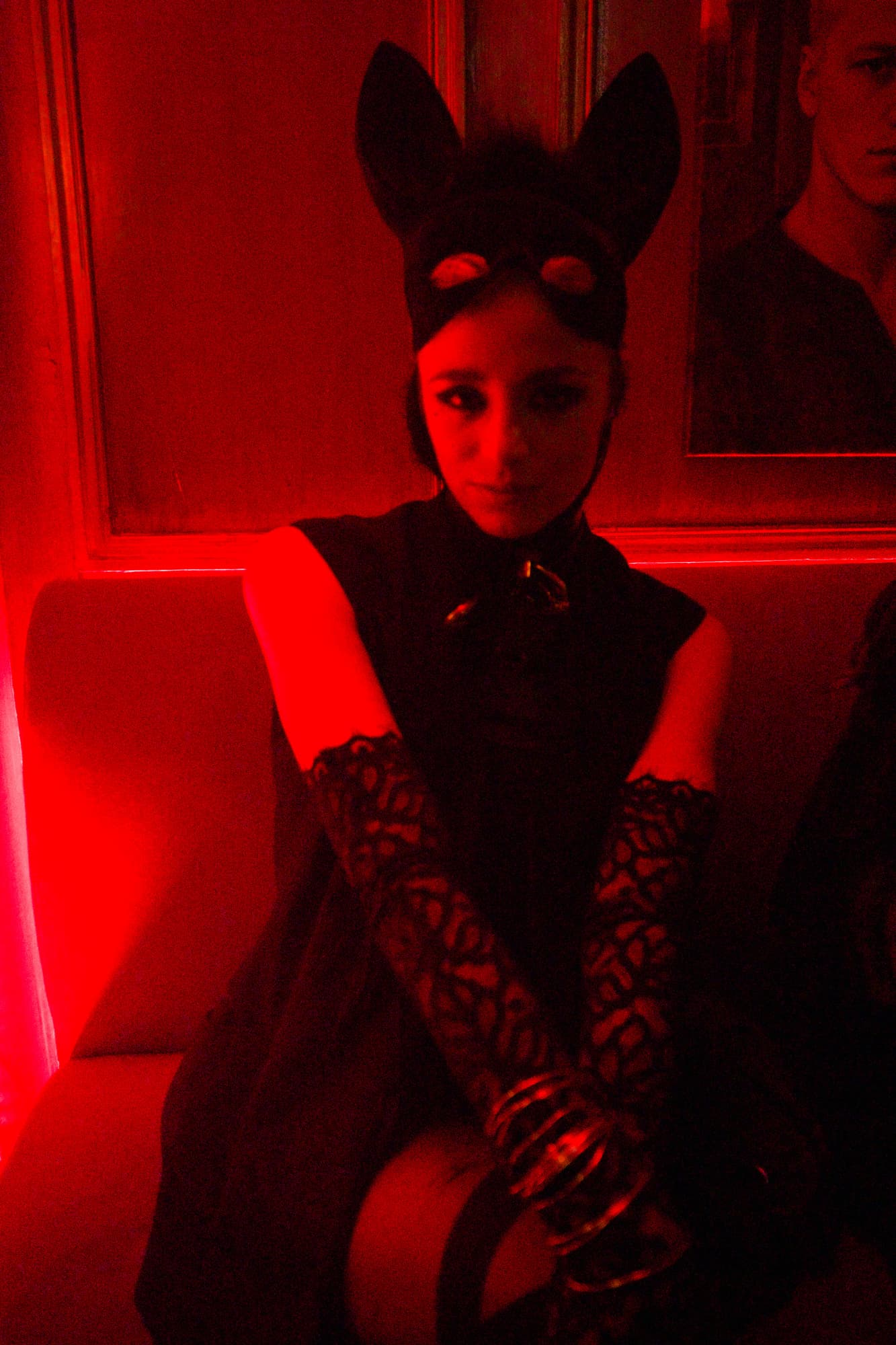 Red-lit masked woman cat costume
