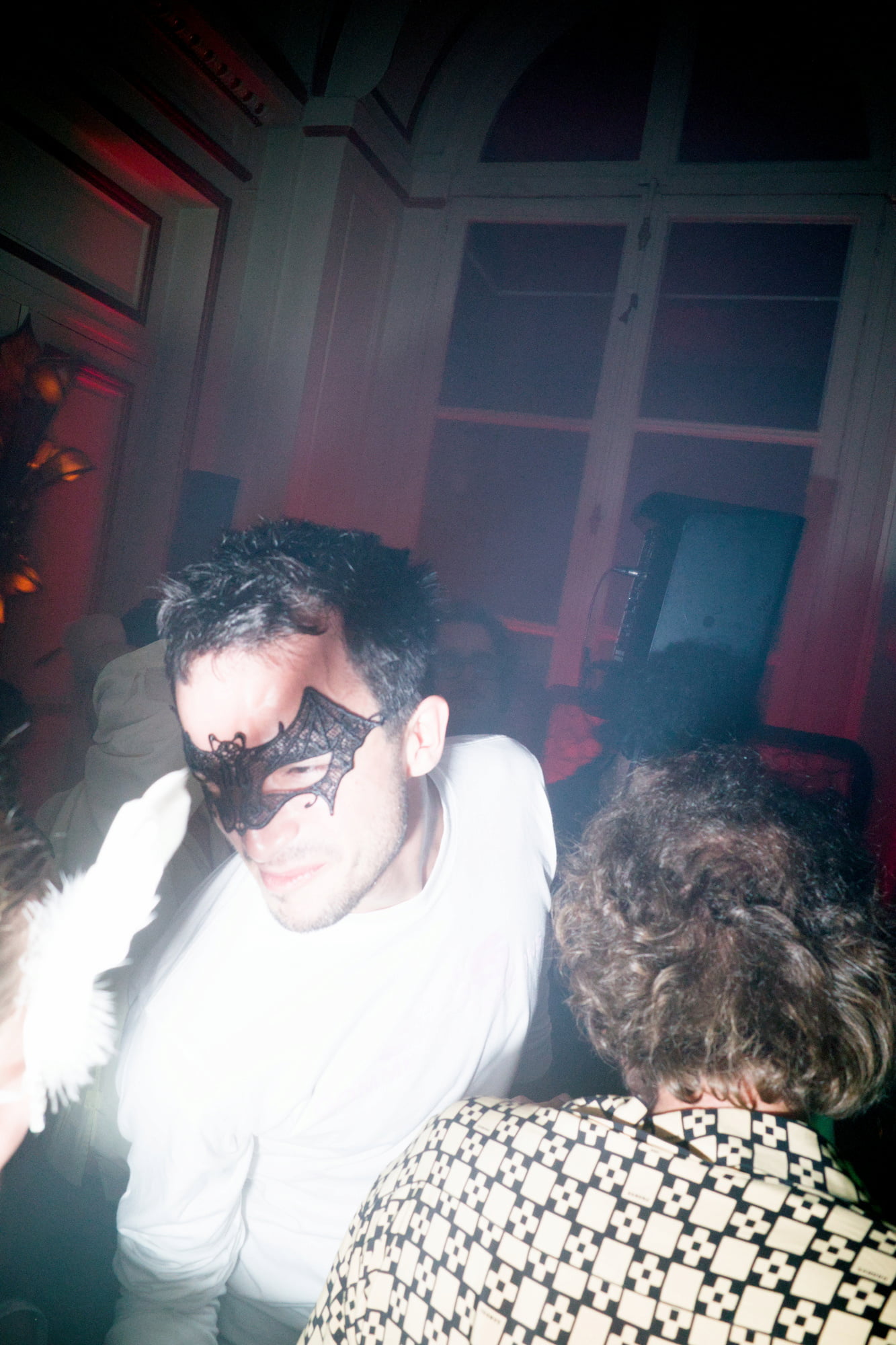 Masked man dancing in smoky room