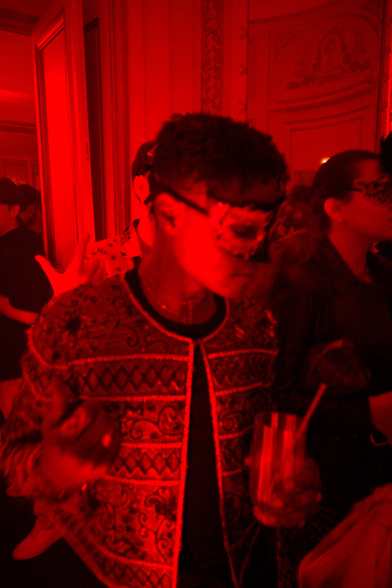 Red lighting masked party crowd