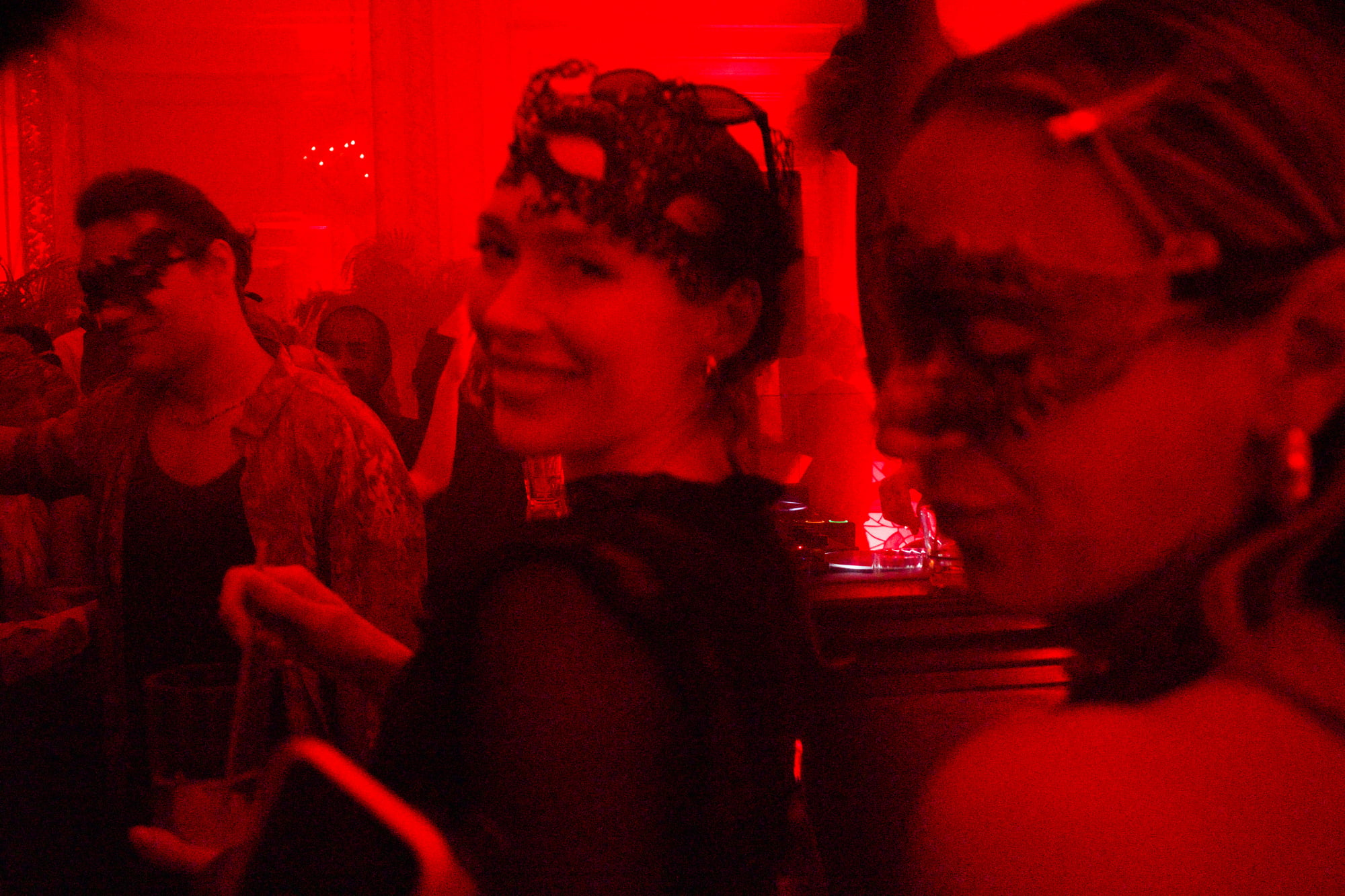 Red-lit dancefloor masked party atmosphere